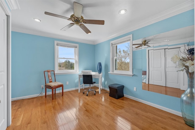 living area with wood-type flooring, baseboards, a ceiling fan, and ornamental molding