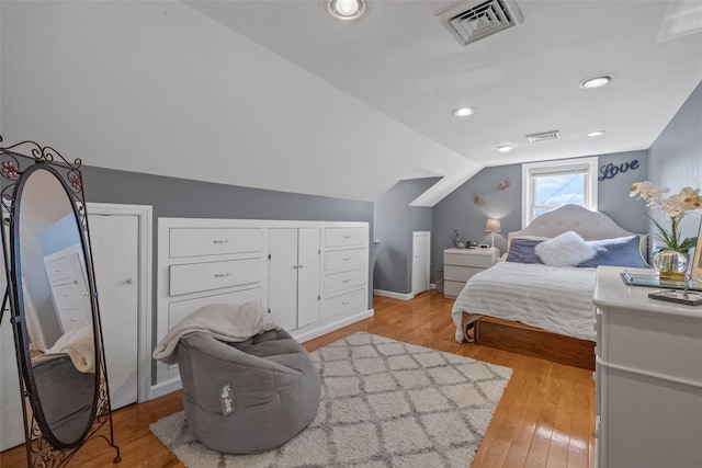 bedroom with light wood-type flooring, vaulted ceiling, visible vents, and recessed lighting