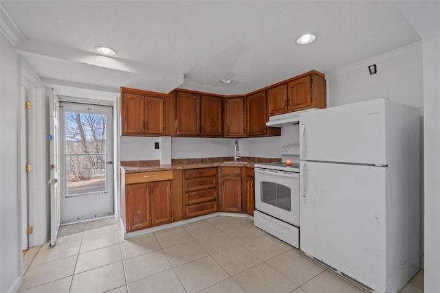 kitchen featuring white appliances, light tile patterned floors, under cabinet range hood, brown cabinetry, and a sink