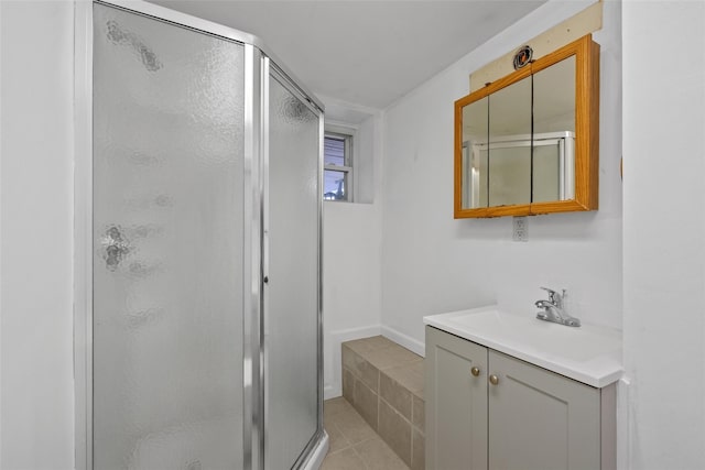 bathroom with tile patterned flooring, a stall shower, and vanity