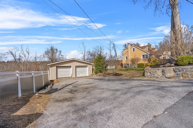 detached garage with driveway and fence