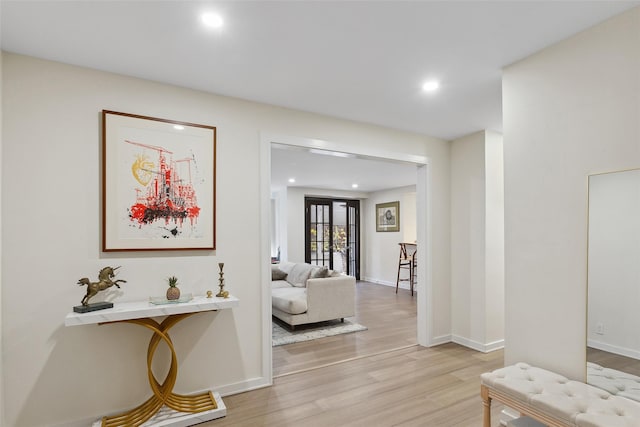 hallway with recessed lighting, light wood-type flooring, and baseboards