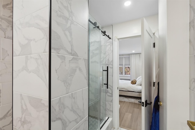 ensuite bathroom featuring recessed lighting, wood finished floors, connected bathroom, and a shower stall