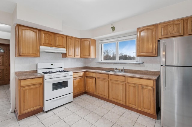 54-30 Kissena Blvd, Flushing, NY 11355 - kitchen with light tile patterned flooring, a sink, freestanding refrigerator, under cabinet range hood, and white range with gas stovetop