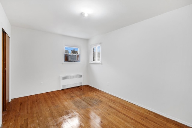 54-30 Kissena Blvd, Flushing, NY 11355 - empty room with radiator, cooling unit, light wood-style flooring, and baseboards