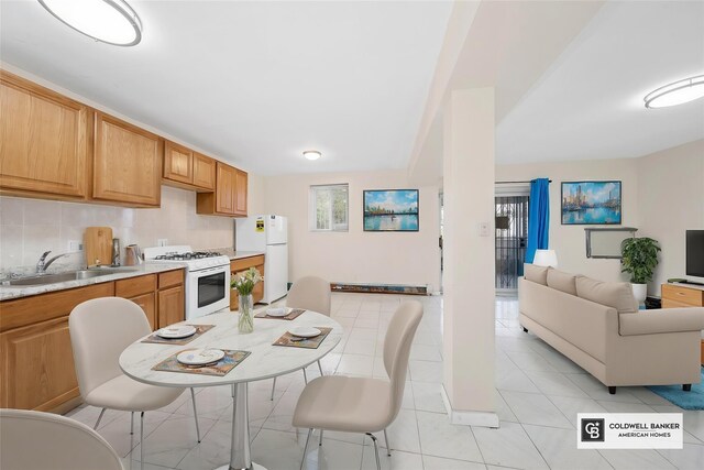 54-30 Kissena Blvd, Flushing, NY 11355 - kitchen featuring light tile patterned flooring, light countertops, white appliances, a sink, and open floor plan