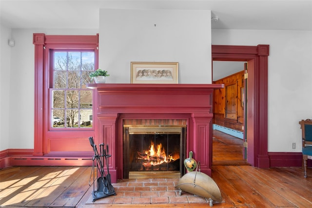 room details featuring wood finished floors, a baseboard heating unit, and a fireplace