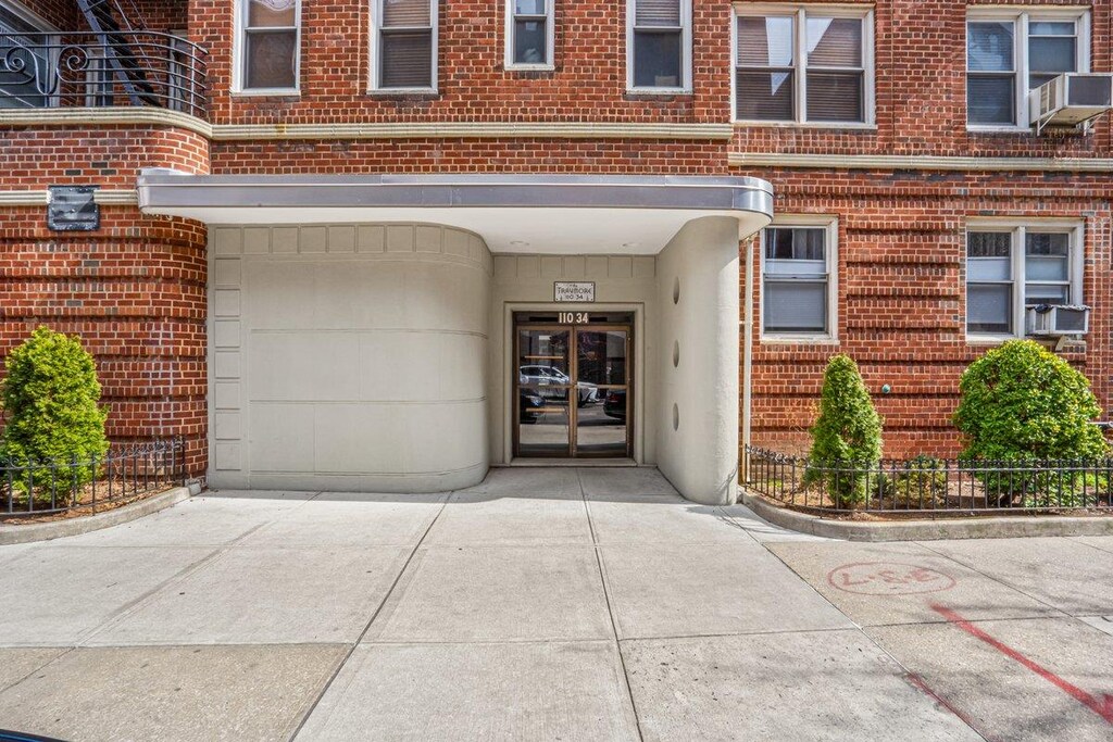 110-34 73rd Rd Unit 6J, Forest Hills, NY 11375 - entrance to property featuring brick siding, a garage, and concrete driveway