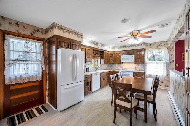 kitchen featuring light countertops, visible vents, white appliances, wallpapered walls, and a baseboard heating unit