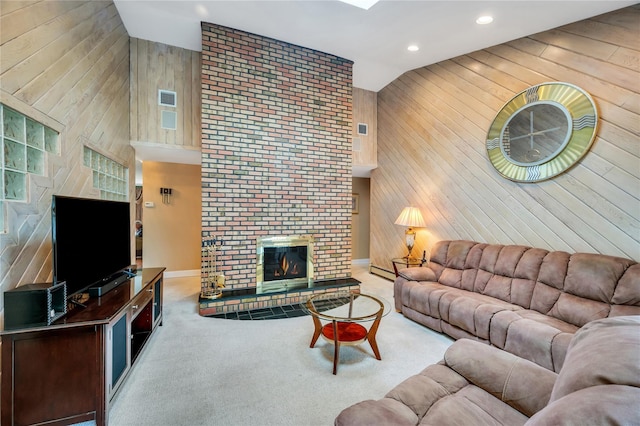 living area with wood walls, high vaulted ceiling, carpet floors, a baseboard radiator, and a fireplace