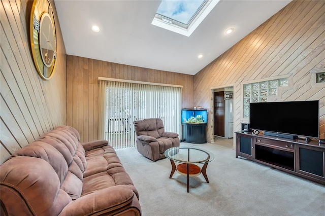 carpeted living room featuring high vaulted ceiling, plenty of natural light, a skylight, and wood walls