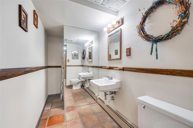 half bath featuring a sink, toilet, tile patterned floors, and baseboard heating