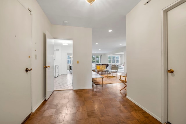 hall featuring recessed lighting, washer / dryer, and baseboards