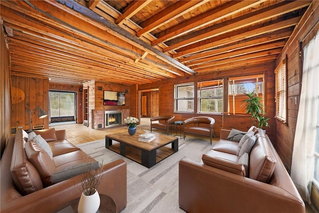 living room with wood finished floors, wooden walls, and a brick fireplace