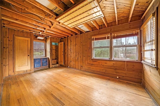 empty room featuring light wood finished floors and wood walls