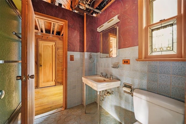bathroom featuring toilet, tile patterned flooring, and a sink