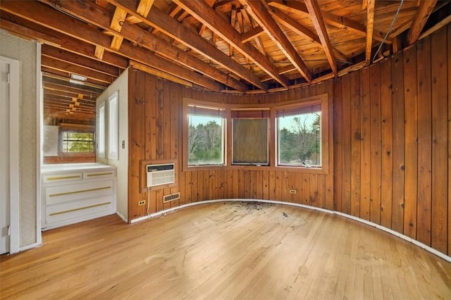 miscellaneous room featuring wood walls, a wealth of natural light, and hardwood / wood-style flooring