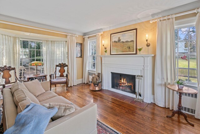 3 Wincoma Dr, Huntington Bay, NY 11743 - living room with crown molding, a warm lit fireplace, wood finished floors, radiator, and baseboards