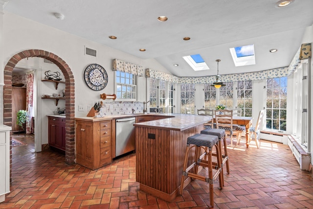 3 Wincoma Dr, Huntington Bay, NY 11743 - kitchen with stainless steel dishwasher, a wealth of natural light, brick floor, and tasteful backsplash