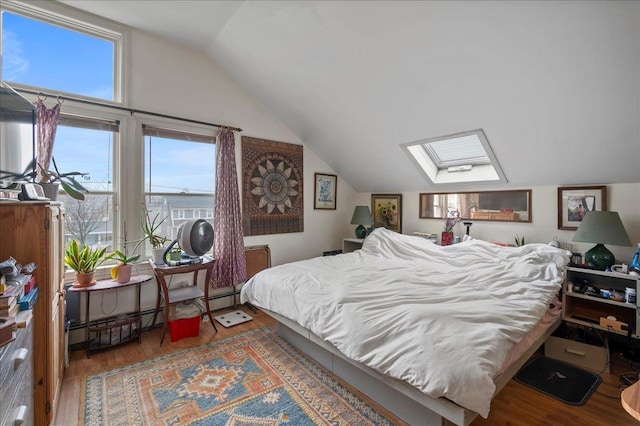 bedroom featuring baseboard heating, vaulted ceiling with skylight, and wood finished floors