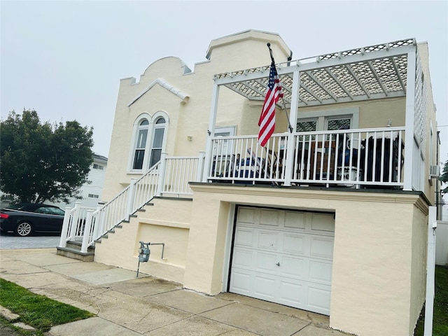 105 Mitchell Ave, Long Beach, NY 11561 - view of front of house featuring an attached garage, stucco siding, and a balcony