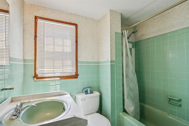 bathroom featuring shower / tub combo, vanity, a wainscoted wall, toilet, and tile walls