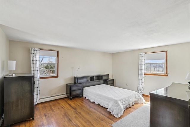bedroom with a baseboard radiator and hardwood / wood-style floors