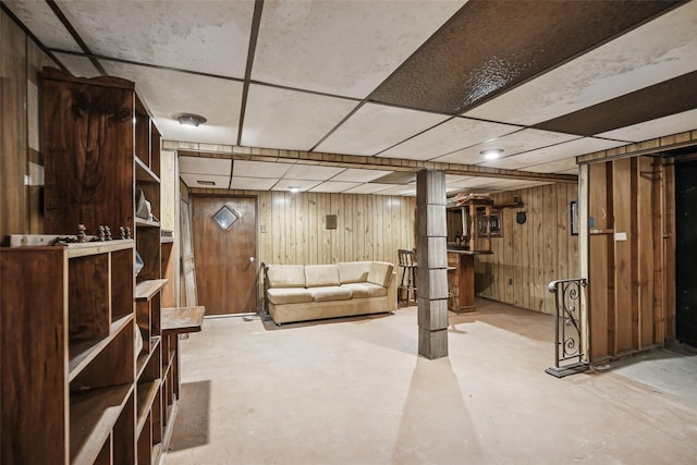 finished below grade area with wood walls and a drop ceiling