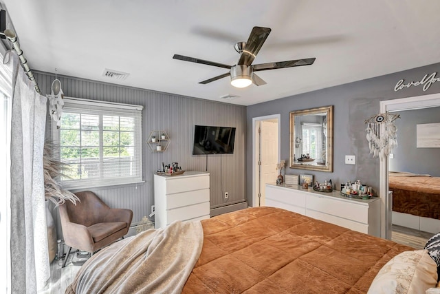 bedroom featuring visible vents, a baseboard heating unit, and ceiling fan