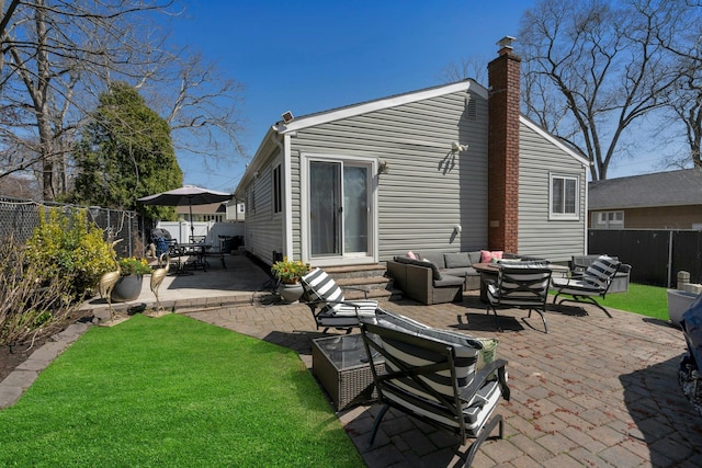 rear view of house featuring outdoor lounge area, a chimney, a patio area, entry steps, and a fenced backyard