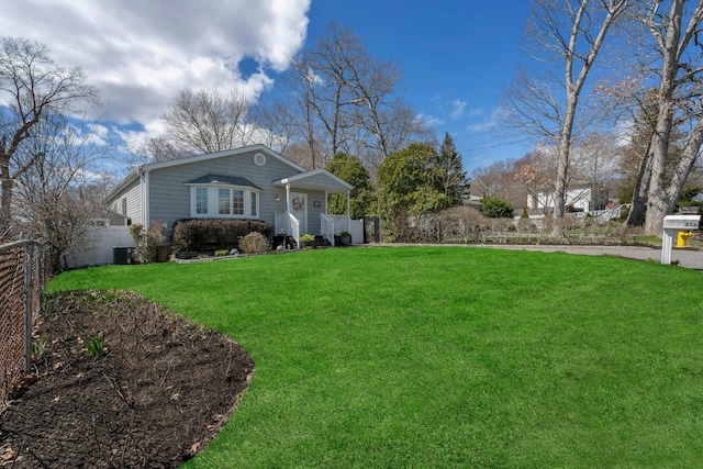 view of yard with central AC unit and fence