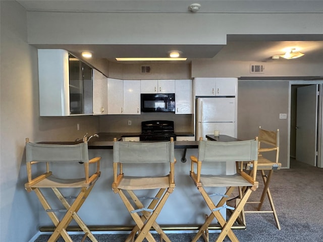 35 Bailey Ct Unit 35, Middle Island, NY 11953 - kitchen featuring freestanding refrigerator, black microwave, range with gas stovetop, dark countertops, and white cabinets