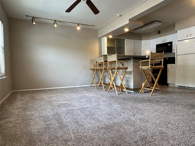 35 Bailey Ct Unit 35, Middle Island, NY 11953 - kitchen featuring freestanding refrigerator, black microwave, a kitchen bar, dark countertops, and a ceiling fan