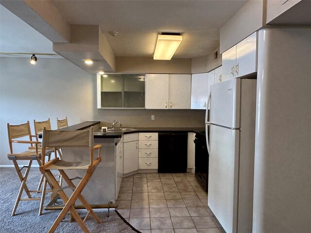 35 Bailey Ct Unit 35, Middle Island, NY 11953 - kitchen with black dishwasher, freestanding refrigerator, a sink, dark countertops, and glass insert cabinets