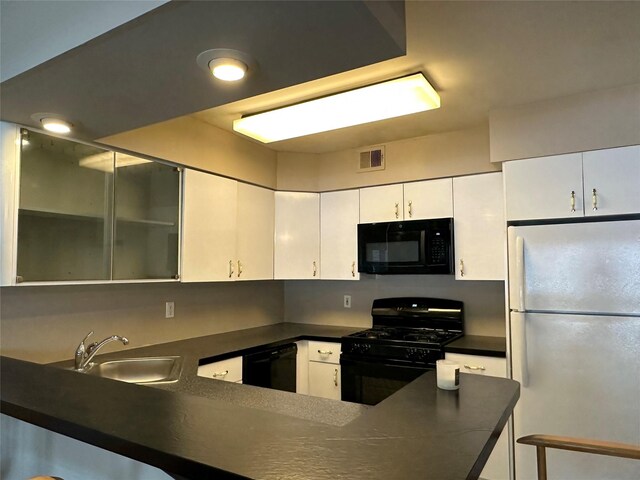 35 Bailey Ct Unit 35, Middle Island, NY 11953 - kitchen featuring black appliances, a sink, dark countertops, white cabinetry, and a peninsula