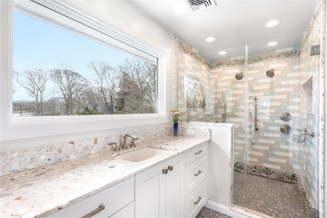 full bath featuring healthy amount of natural light, a shower stall, recessed lighting, and vanity