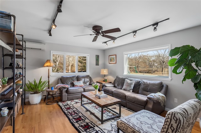 living area featuring track lighting, plenty of natural light, and ceiling fan