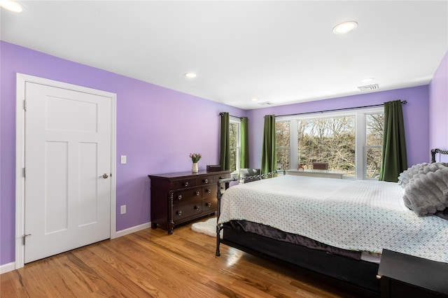 bedroom featuring baseboards, wood finished floors, and recessed lighting