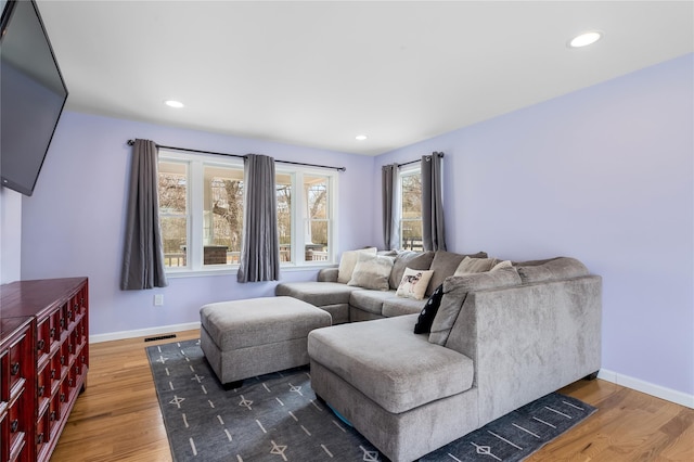 living room with wood finished floors, baseboards, and recessed lighting