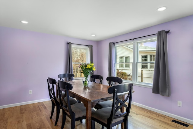 dining room with plenty of natural light, baseboards, light wood-type flooring, and recessed lighting