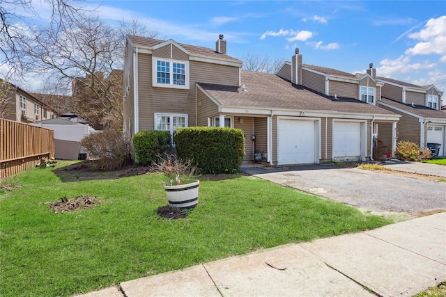 view of front of home featuring driveway, a chimney, a front yard, and a garage