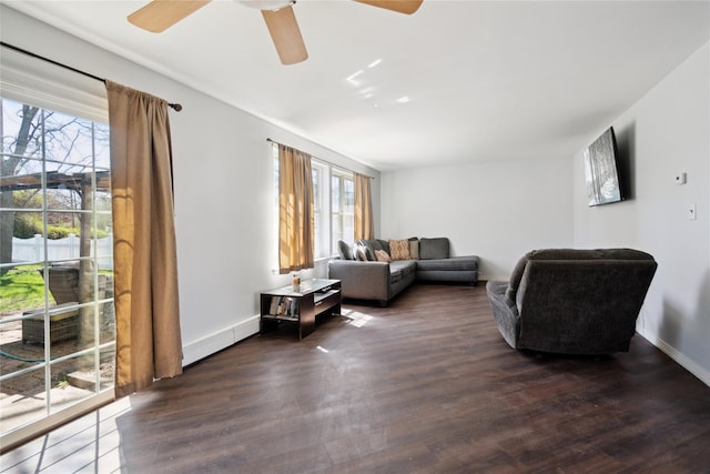 living area featuring dark wood-style floors, ceiling fan, and a healthy amount of sunlight