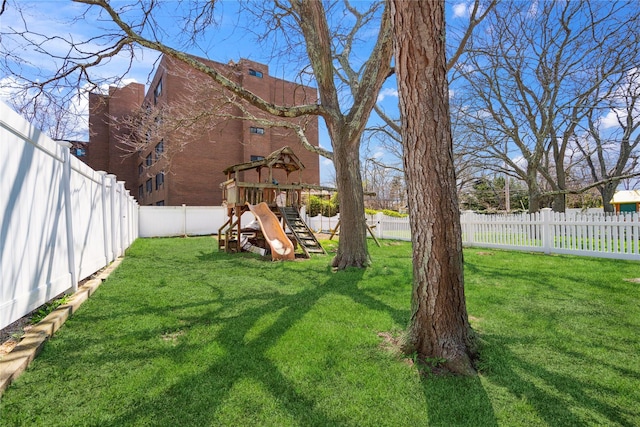 view of yard with a fenced backyard and a playground