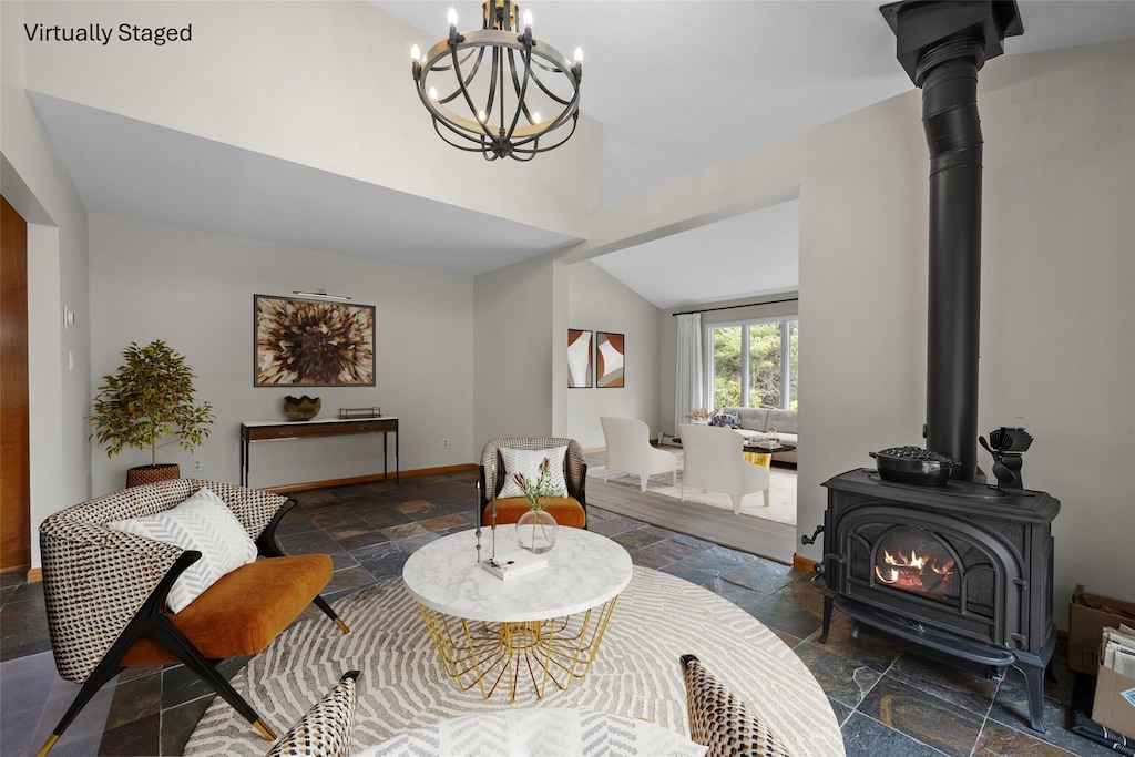 863 Crystal Lake Rd, Narrowsburg, NY 12764 - living room with a wood stove, lofted ceiling, baseboards, stone tile flooring, and a notable chandelier