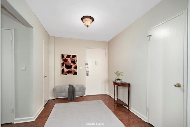 entryway with baseboards and dark wood-style flooring