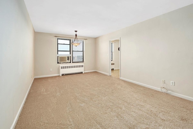 empty room featuring baseboards, light carpet, radiator heating unit, and cooling unit