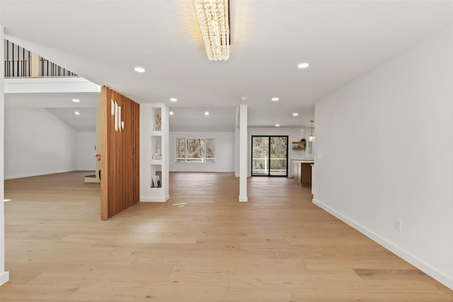 hall with recessed lighting, light wood finished floors, a notable chandelier, and baseboards