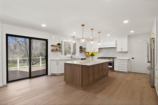 kitchen with stainless steel range, light countertops, a healthy amount of sunlight, and a sink
