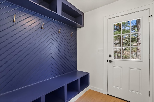 mudroom featuring light wood finished floors and baseboards