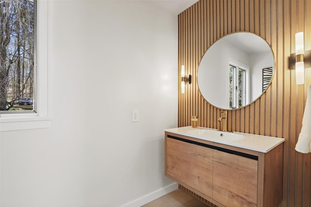 bathroom with tile patterned flooring, vanity, baseboards, and wallpapered walls